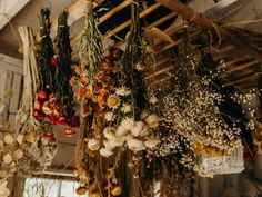 dried flowers hanging from the ceiling in a room with wooden rafters and other decorations