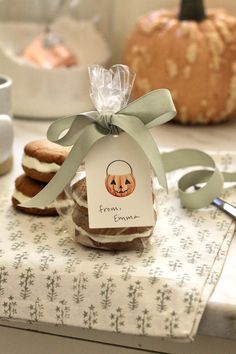 some cookies are wrapped in cellophane and sitting on a table next to a pumpkin