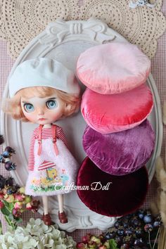 the doll is standing next to three hats