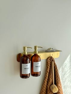 two bottles of soap are hanging on the wall