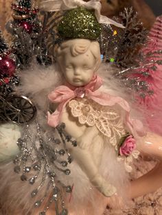 an angel figurine sitting on top of a table next to other christmas decorations