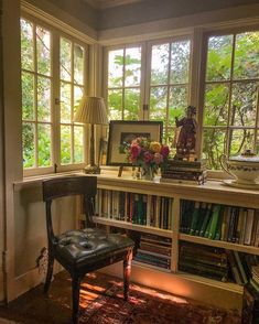 a chair sitting in front of a window next to a book shelf filled with books