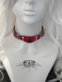 This red choker features a decorative inverted cross pendant adorned with studs. Add a touch of edgy style to your look with this statement piece. Perfect for adding a bold and unique touch to any outfit, this choker is a must-have accessory for those who love to stand out. Made with high-quality materials, it is both durable and eye-catching. Ideal for those who love to express their individuality through fashion.  The price is for a choker only, others are not included. Red Choker, Inverted Cross, Steampunk Fashion Male, Cross Choker, Punk Accessories, Leather Rivets, Tie Necklace, Steampunk Accessories, Heart With Wings