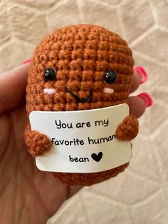 a small crocheted stuffed animal holding a label that says, you are my favorite human bean