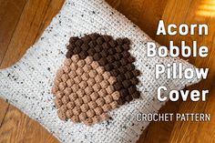 a crocheted pillow with an acorn on it and the words acorn bubble pillow cover