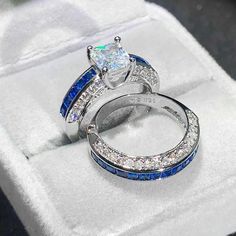 two wedding rings with blue and white diamonds