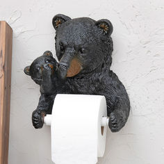 a black bear and her cub sitting on top of a toilet paper roll holder with their noses to each other