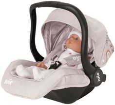 a baby doll in a car seat with the hood up and head turned to the side