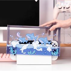 a person is holding a video game controller in front of a box with dolphins on it