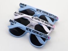 three sunglasses with we're poppin bottles printed on the sides, one blue and one white