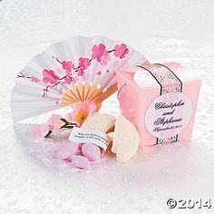 a pink and white parasol next to a small box with soaps on it