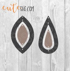 an image of two black and brown tear shaped earrings on a white wooden background with the words cut & svg com