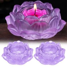 a purple candle sitting on top of a glass bowl next to two smaller pink candles