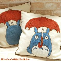 two pillows with cartoon characters holding umbrellas