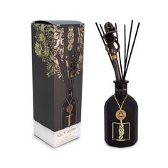 a black bottle filled with reeds next to a box