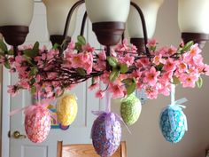 an arrangement of easter eggs hanging from a chandelier