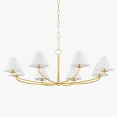 a brass chandelier with white shades