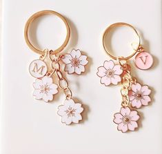 two key chains with flowers and initial charms