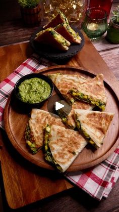 quesadillas with guacamole and salsa on a wooden platter