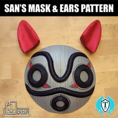 an animal mask with ears and horns on top of a wooden table next to the words, san's mask & ears pattern