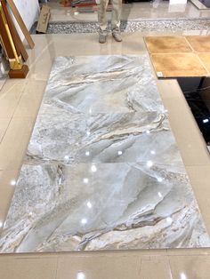 a man is standing in front of a marbled area rug on the floor at a store