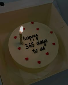 a birthday cake with a lit candle on it that says happy 365 days to us