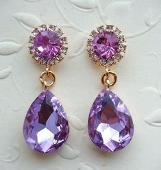 This is a statement earrings. Elegant, opulent, and shimmery, this show stopping earrings feature a rich palate. This brilliant classic earrings features purple Swarovski crystals. Crystals are set on a secure prong settings, made of brass and plated in 18 karat gold.. These earrings have surgical steel posts and measure 1.25" in length. These luxury earrings are bold and beautiful, and make a powerful statement. These stunning dangle earrings are unique, feminine and eye-catching, Perfect for a Elegant Lavender Earrings For Party, Elegant Lavender Jewelry For Evening, Elegant Lavender Evening Jewelry, Purple Drop Chandelier Earrings For Formal Occasions, Lavender Drop Earrings For Party, Elegant Purple Dangle Chandelier Earrings, Purple Crystal Earrings For Wedding, Purple Dangle Bridal Earrings For Formal Occasions, Purple Bridal Earrings For Party