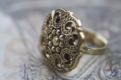 It's like a pretty shield! Elegant Nickel-free Gold Rings, Vintage Gold Metal Rings, Vintage Gold Filigree Ring With Intricate Design, Gold Vintage Filigree Ring With Intricate Design, Elegant Nickel-free Brass Ring, Classic Brass Wedding Rings, Elegant Nickel-free Yellow Gold Rings, Vintage Gold Filigree Ring, Gold Vintage Filigree Ring