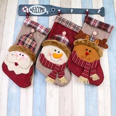 three christmas stockings hanging on a wall with snowmen and santa clauss in them