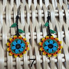 Traditional Mexican Handmade Huichol chaquira (beaded) earrings made by Mexican artisans in the Mexican state of Chipas. The earrings are lightweight, colorful and sure to bring you lots of compliments.  The length is approximately 3 inches and 1.5 inches wide. Traditional Multicolor Flower Earrings With Dangling Beads, Bohemian Beaded Round Flower Earrings, Unique Multicolor Flower-shaped Beaded Earrings, Handmade Traditional Flower Earrings For Festivals, Traditional Handmade Flower Earrings For Festivals, Traditional Multicolor Flower Earrings, Traditional Yellow Earrings For Summer, Handmade Multicolor Flower Earrings With Round Beads, Adjustable Multicolor Flower Earrings With Colorful Beads