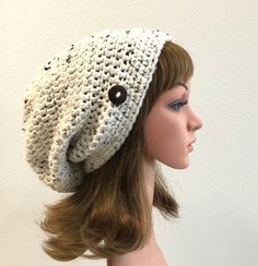 a mannequin head wearing a crocheted hat with buttons on the side