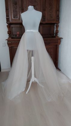 a mannequin wearing a white wedding dress with a long veil on it's head