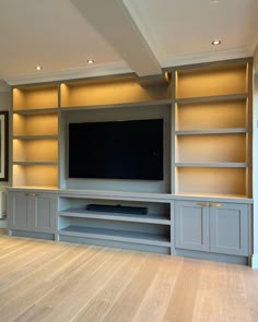 a large entertainment center with built - in shelves and a flat screen tv on the wall