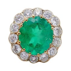 A classic cluster 18 karat yellow gold ring with a Colombian emerald and diamond. The emerald comes with a GRS Gemstone Report. This gorgeous gold ring features a faceted oval emerald surrounded by a halo of fourteen bezel set diamonds (please see details below). Colombian emeralds are considered the purest and highest quality emeralds on the planet. Cluster rings are always in fashion. This massive vintage emerald ring is a head-turner and your perfect companion for a cocktail party. This bold French vintage cocktail ring is made of 18 karat yellow gold and features an approximately 7.70-carat oval faceted emerald (13.80 x 12.14 x 8.69 mm), accented with fourteen round brilliant cut diamonds (G-H color, VS clarity, total weight 2.10 carats). This emerald ring top measures 13/16” x ¾” x 3/