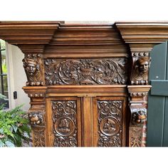 an ornate carved wooden bed frame with lion heads on the top and bottom paneling