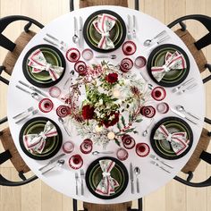 an overhead view of a dining table with place settings and flowers on the centerpiece