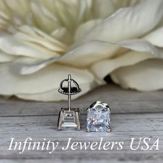 "The stud earrings pictured are simulated diamond #5036 Approximate total carat weight: approx. 2.00ctw diamond equivalent -Center Stone Size: 6x6mm - approx. 1.00ct each diamond equivalent -Center Stone Shape: radiant cut -Gem Type: simulated diamond -Stone Clarity: VVS1 -Stone Color: D -Moh's Scale: 8.5 hardness -Metal Type and Purity: 14k white gold -Setting: 4 prong basket head -Backing: friction back (earring backs are subject to change due to availability) -Country of Manufacturing: USA (M Emerald Cut Lab Grown Diamond Jewelry For Anniversary, Gia Certified Silver Diamond Earrings For Gift, White Diamond Earrings With Accents For Anniversary, Oval Diamond Bridal Earrings For Anniversary, Gia Certified Sterling Silver Earrings For Anniversary, Gia Certified Fine Jewelry Earrings For Anniversary, Cubic Zirconia Bridal Earrings With Diamond Accents For Anniversary, Bridal Cubic Zirconia Earrings With Diamond Accents For Anniversary, Gia Certified Oval Diamond Earrings For Anniversary