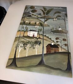 an image of a painting on a table with trees and houses in the background,