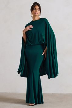 Wedding season calls for an elegant addition like Charmaine. Crafted in a classic bottle green shade of our signature stretch jersey, this maxi is defined by an extravagant cape detail and demure high neckline. Flourished with some sparkling stilettos like Oh Please, this maxi dress is perfect for any black tie event.  Features - Premium stretch jersey- High neckline - Button-closed collar- Keyhole cut-out- Cape sleeves- Maxi length Sizing & Fit Model is 5'8 and wears UK size 8 / US size 4 Product Information Designed exclusively by Club L London Double layered with good stretch Premium jersey in Bottle Green (95% Polyester, 5% Elastane) 155cm total length SKU: CL131025047 Dress Minimal, Dress With Cape, Midi Bridesmaid Dress, High Neck Maxi Dress, Sporty Dress, Lace Dress Vintage, Party Dress Long Sleeve, Statement Dress, Long Sleeve Knit Dress