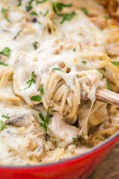 a red bowl filled with pasta and mushrooms