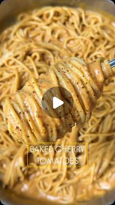 a pan filled with baked cherry tomatoes and noodles, being stirred by a ladle