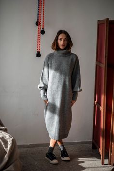 "The winter season is about cozy knitwear and chunky turtlenecks, and this Merino wool dress is about to become your favorite knit. Without a doubt, you do not have to wait for the winter. It is a perfect dress that will easily blend into your fall wardrobe. The minimalist loose silhouette and the hem below the knees will work for everyone with everything, as this is a wardrobe staple that will never go out of style. The flattering raglan shoulders guarantee you will feel at ease, and the wide sleeves gathered at the cuffs will add some sophistication to your hand movements. Pair this wool sweater dress with statement jewelry and modern footwear to look and feel relaxed and confident. WHY PATIS PROJECT? Patis Project is a sustainable slow-fashion brand making timeless staples for the moder Wool Long Dress, Knitted Dress Outfit Winter, Wool Dress Winter, Grey Dress Outfit, Long Jumper Dress, Dress With Sweater, Knitted Dress Outfit, Cozy Knitwear, Wool Dresses