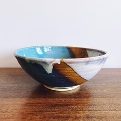 a blue and white bowl sitting on top of a wooden table