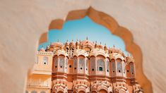 an ornate building is seen through a hole in the wall