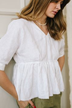 "Ruffled Linen Top is destined to cheer you up. The Peplum Top is designed in a relaxed fit complemented with a breezy raw hem and looks really airy and delicate. Being an easy fit, this white linen blouse is ideal for summer, matching the weather and the vibes. The plunging V-neck accentuates the area slimming your neck and makes it seem longer. This blouse will be a trusty attire in your wardrobe, which you can combine with various pants and shorts. DETAILS ⚬ Raw hem. ⚬ Decorated with handmade Relaxed Fit V-neck Blouse For Brunch, White Relaxed Fit Breezy Tops, Feminine Linen V-neck Blouse, White V-neck Top For Casual Gatherings, Feminine Linen Tops With Relaxed Fit, Feminine Linen Relaxed Fit Tops, White Flowy Breezy Blouse, White Spring Blouse For Casual Gatherings, Breezy Flowy White Top