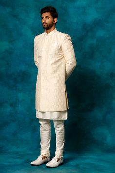 VASTRAMAY Men's Beige Imported Jacquard Indo With Kurta Pyjama Set Elevate your ethnic wear collection with this beige indo-western sherwani set. Crafted from a silk blend, this set features a jacquard patterned sherwani with a mandarin collar, button closure, and full sleeves. The kurta is a classic cream color with a mandarin collar, full sleeves, and pockets, and the set is completed with matching pyjamas. Dry clean only. Key Features Beige Indo-Western Sherwani Set Silk Blend Fabric Jacquard Beige Sherwani For Traditional Ceremonies And Festive Occasions, Festive Beige Sherwani For Traditional Ceremonies, Beige Kurta With Traditional Drape For Ceremonial Occasions, Beige Straight Kurta Sets For Transitional Season, Ceremonial Beige Sets With Traditional Drape, Ceremonial Beige Traditional Drape Sets, Beige Ceremonial Sets With Traditional Drape, Festive Beige Nehru Jacket, Transitional Beige Set With Traditional Drape