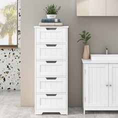 a white cabinet and sink in a room with a plant on top of the cabinet