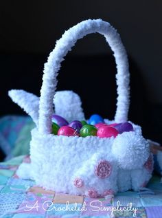 a white basket filled with easter eggs on top of a table