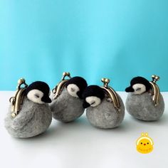 four stuffed penguins are lined up next to each other