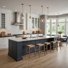 a large kitchen with an island and bar stools